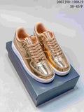 Pair of metallic gold low-top sneakers displayed on a dark shoebox, with white soles and tonal laces.