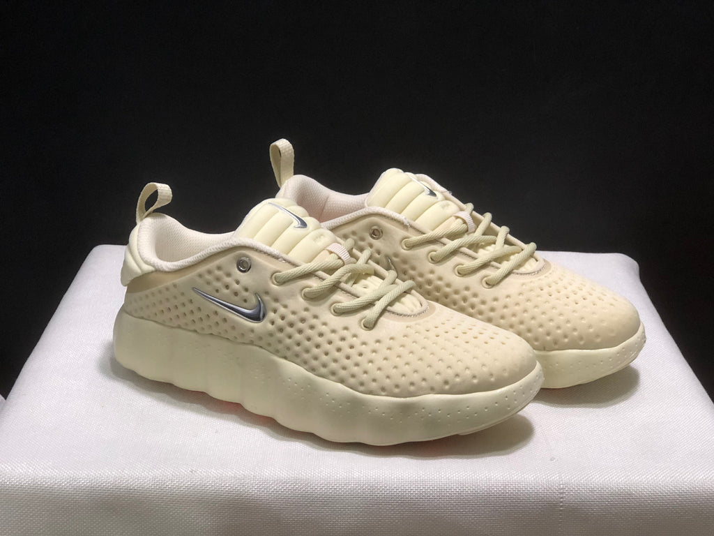 Front three-quarter view of the cream sneaker pair showing the perforated-looking uppers and thick sculpted soles.
