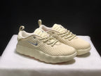 Front three-quarter view of the cream sneaker pair showing the perforated-looking uppers and thick sculpted soles.