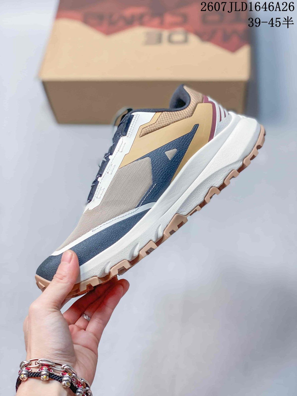 Side profile showing the mesh upper, navy side overlay, white midsole and tan lugged outsole.