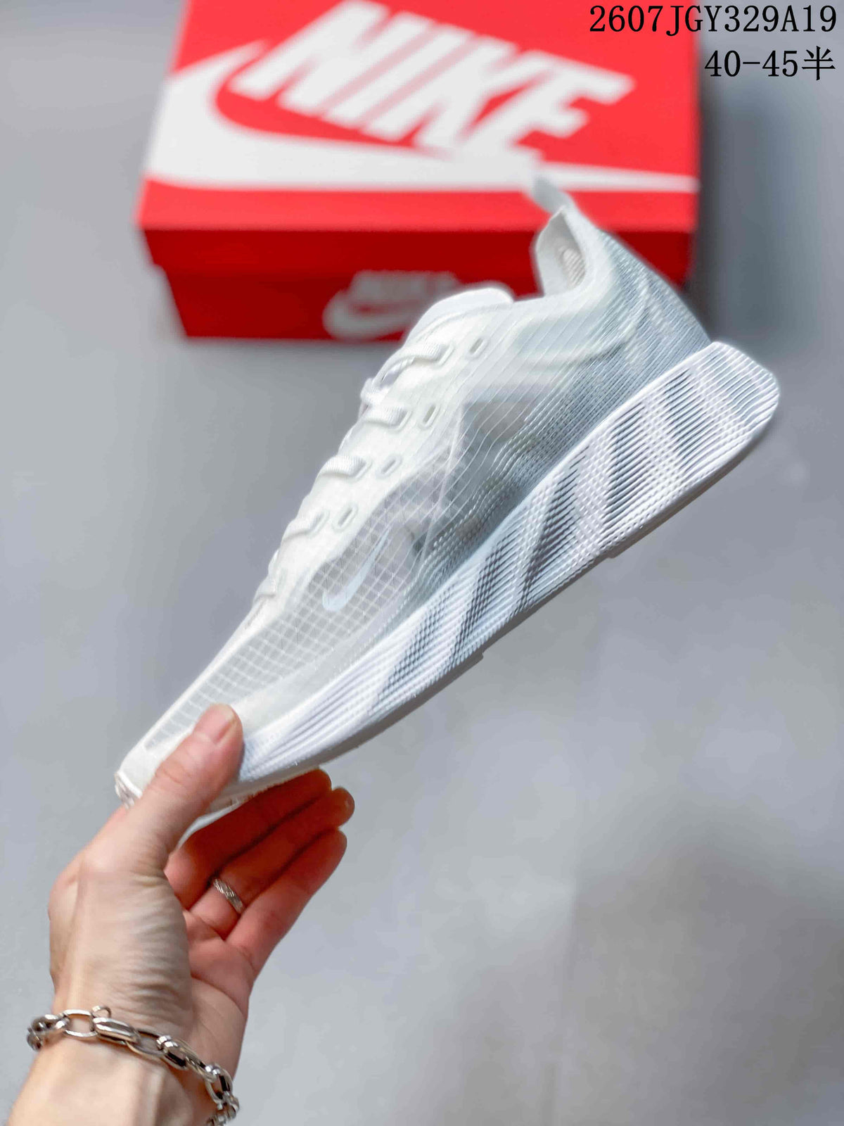 Side profile of the white low-top sneaker showing the translucent grid-patterned upper, Nike Swoosh, and layered white sole.