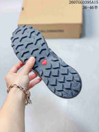Close view of the Salomon shoe outsole showing a dense pattern of pronounced directional lugs and a red Salomon detail.