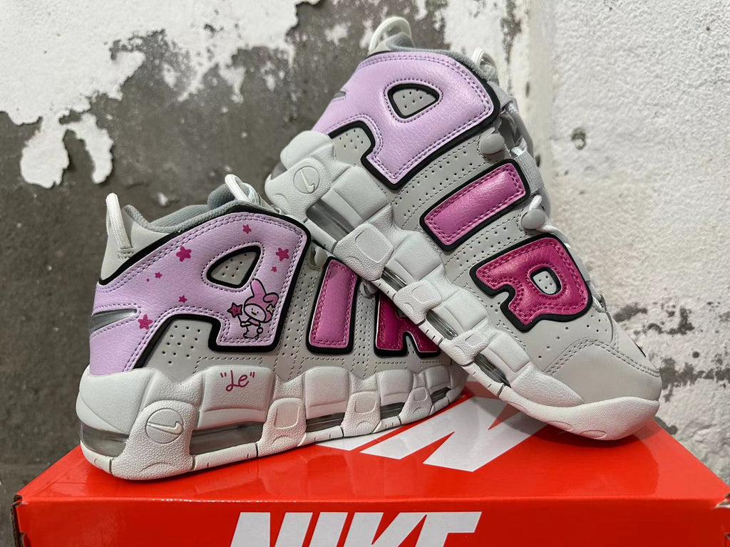 Pair of gray and white Nike sneakers with pink AIR lettering, lavender rabbit graphics, and visible cushioning.
