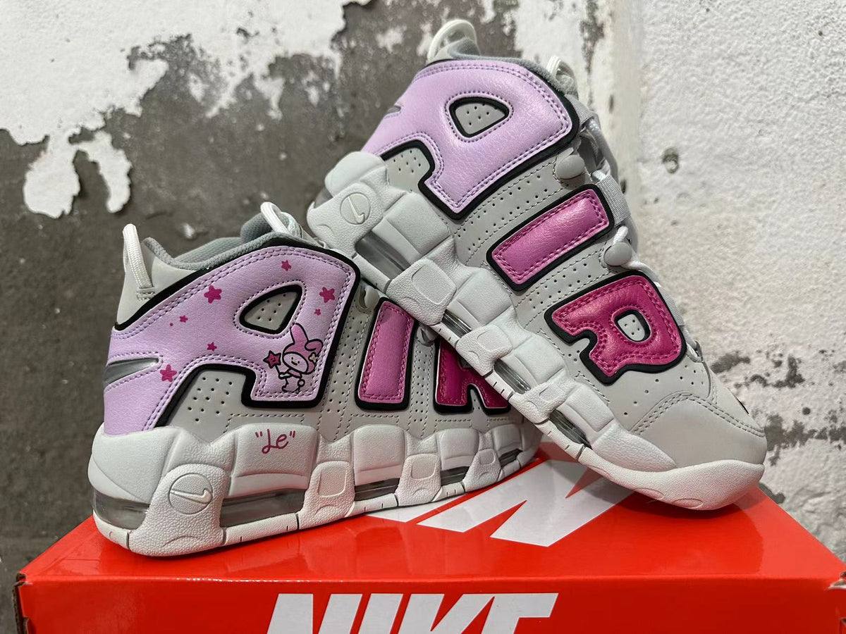 Pair of gray and white Nike sneakers with pink AIR lettering, lavender rabbit graphics, and visible cushioning.
