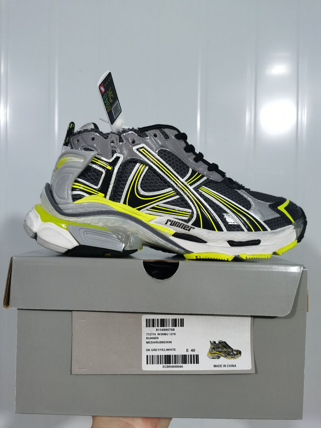 Side profile of the sneaker displayed on its box; the label shows W3RMU 1279, RUNNER, DK GREY/WHITE and sample size E 40.