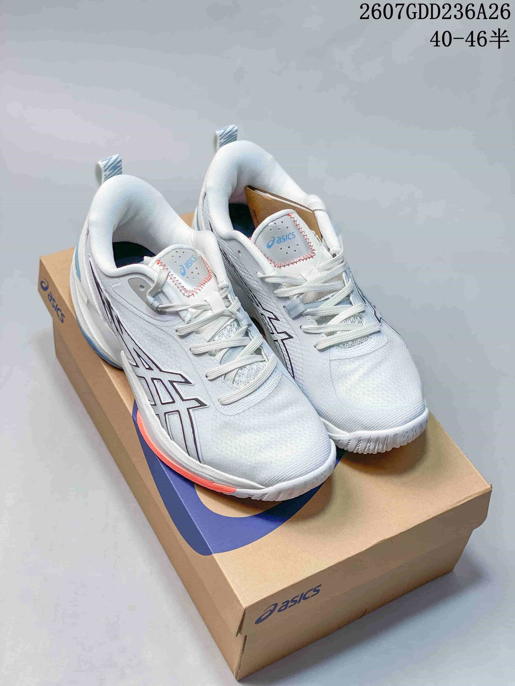 White ASICS Swiftace basketball shoes with dark and orange outsole accents displayed on an ASICS shoebox.