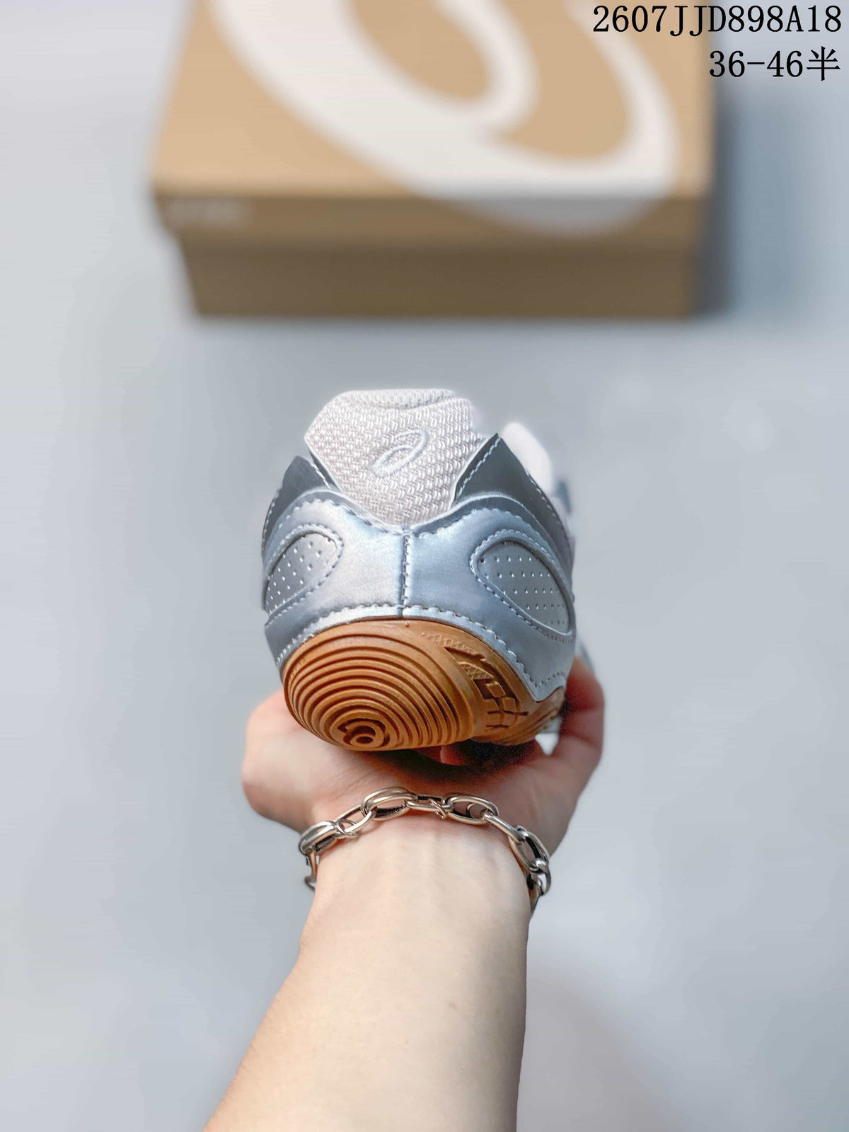 Rear view of the sneaker showing the padded heel, ASICS branding, and gum-colored heel traction section.