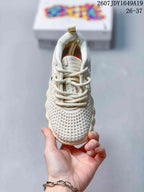 Front view of the cream sneaker showing the perforated toe box, tongue, and cream laces.