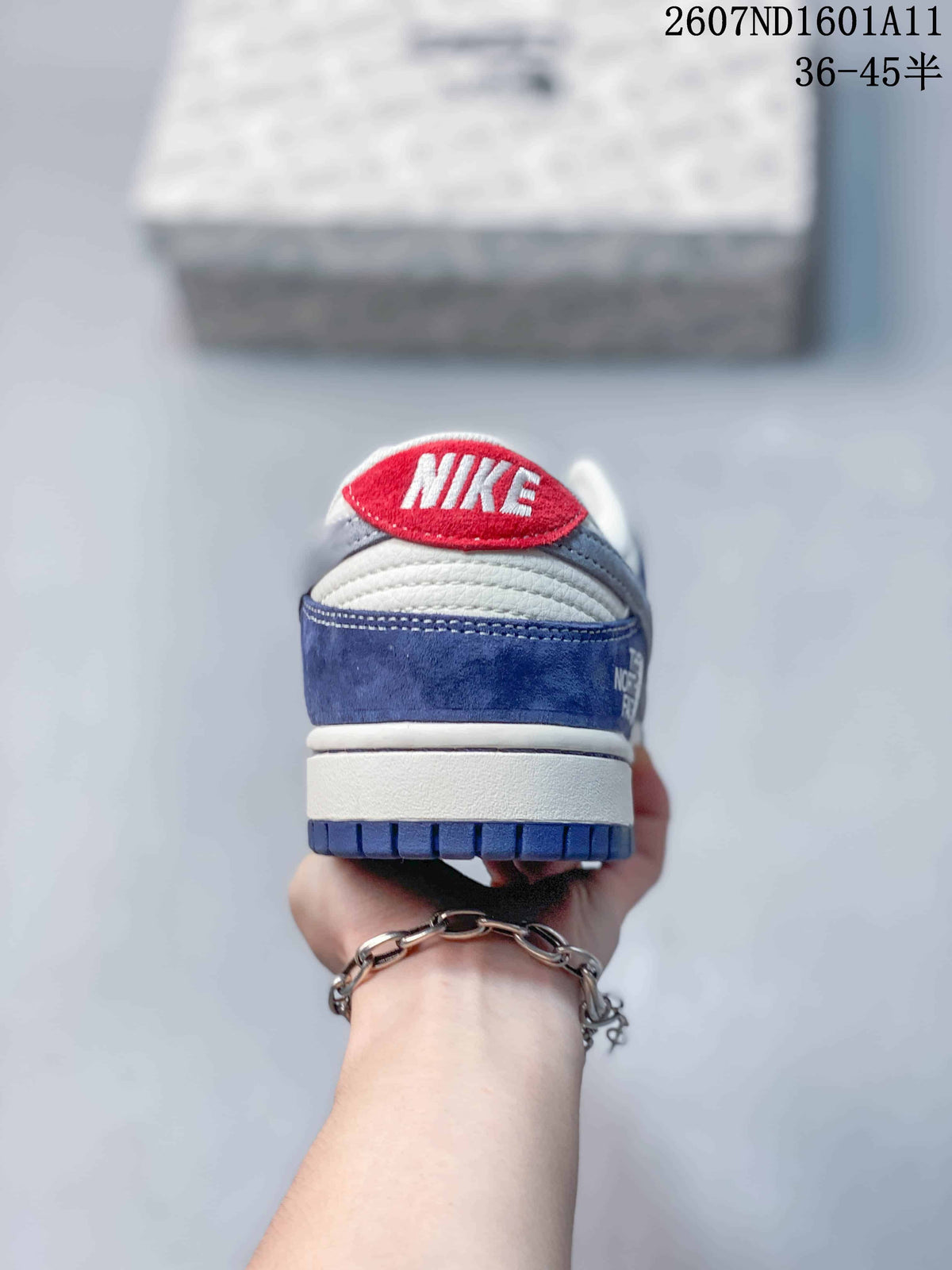 Rear view of the sneaker showing a red Nike heel tab, blue heel overlay, white midsole, and blue outsole.