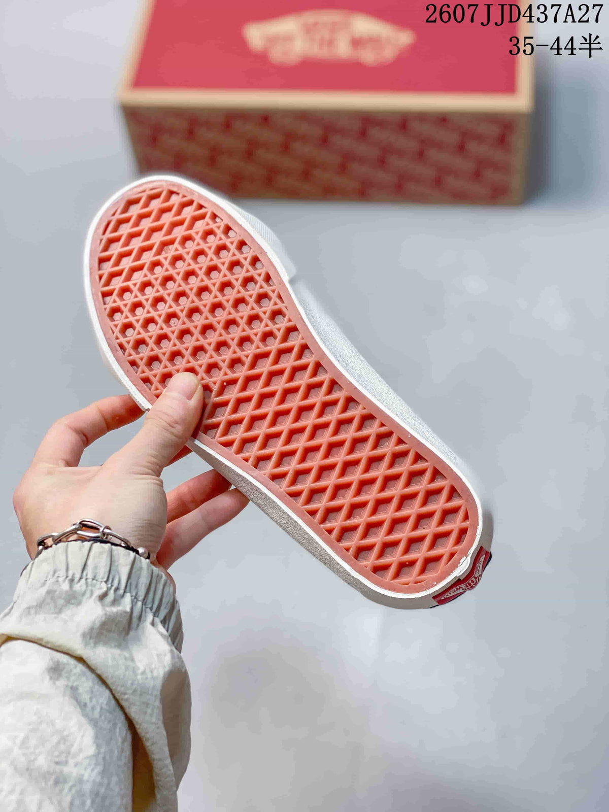 Close view of the sneaker's orange waffle-pattern rubber outsole and Vans shoebox.