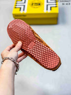 Underside of a sneaker showing a red-brown textured rubber outsole with a diamond tread pattern.