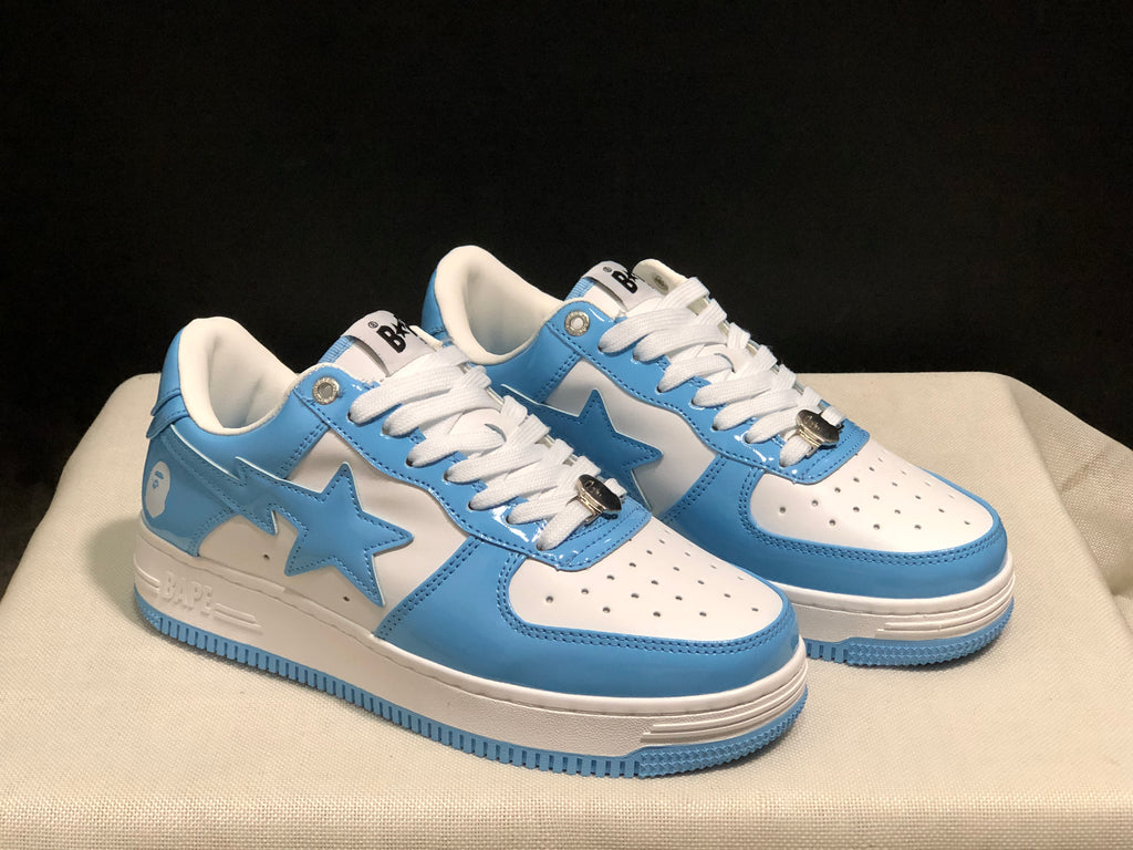 Three-quarter front view of the blue and white sneaker pair with perforated toe panels and white laces.