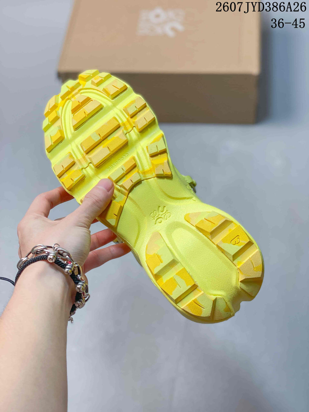 Close view of the neon yellow sneaker outsole showing open tread sections and raised yellow traction blocks.