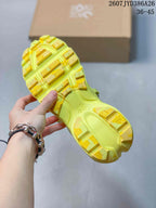 Close view of the neon yellow sneaker outsole showing open tread sections and raised yellow traction blocks.