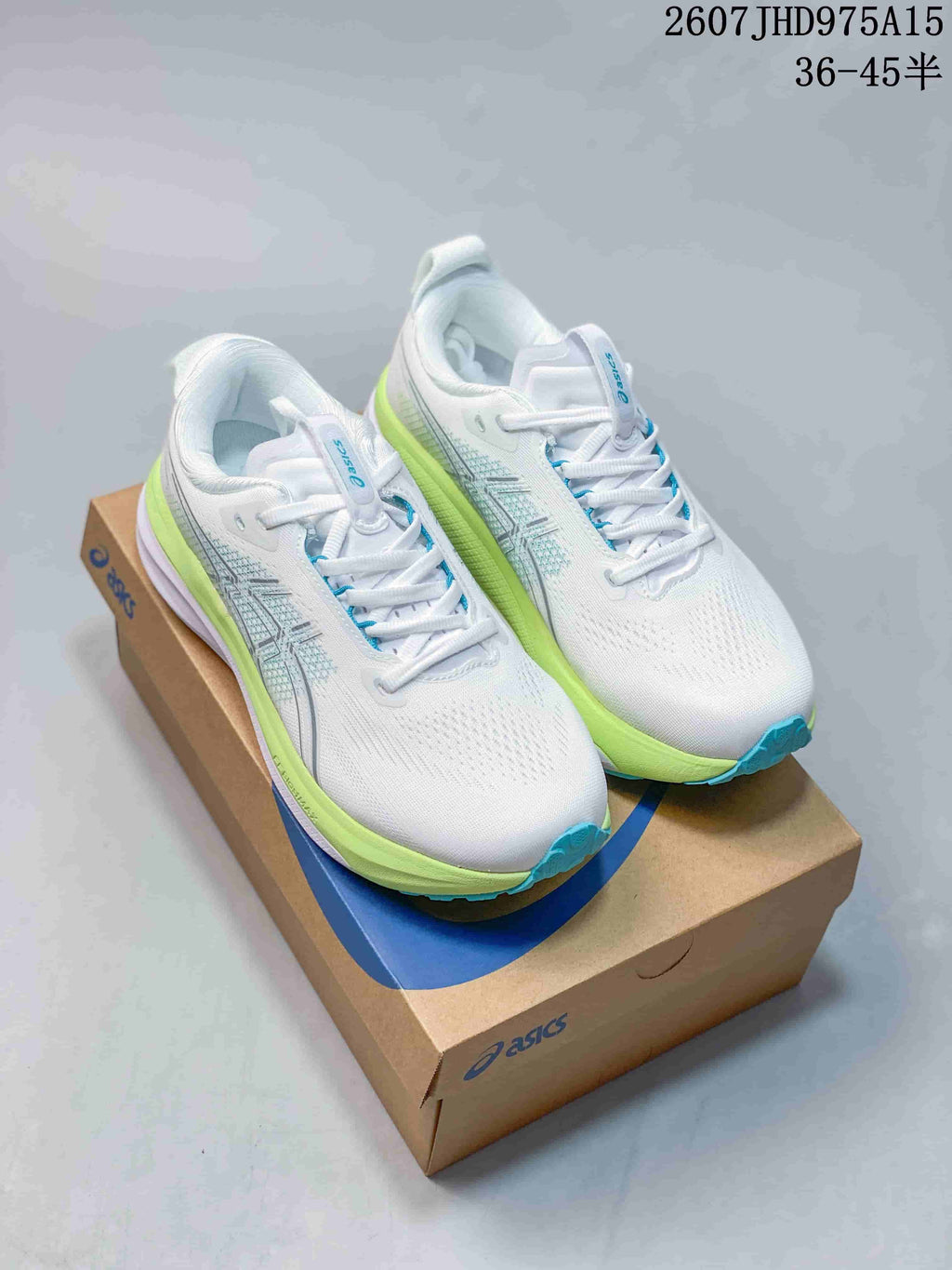 Pair of white ASICS sneakers with lime-green midsoles and blue outsole accents on an ASICS shoebox.