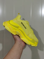 Close side view of the yellow Balenciaga sneaker showing the visible Balenciaga branding and layered outsole.