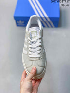 Top view of the sneaker showing white laces, light gray panels, and an adidas tongue label.