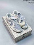 Pair of grey and white low-top sneakers displayed on a patterned shoe box, with an additional lace set and a hangtag visible.