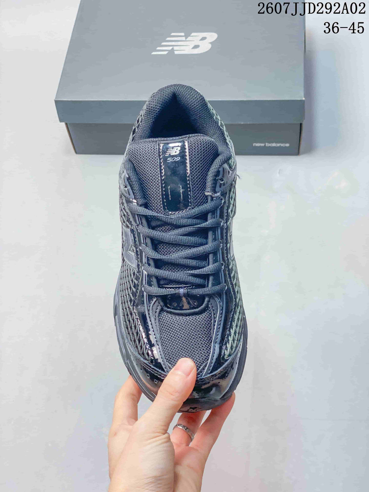 Top view of the dark gray New Balance 509 sneaker showing the mesh tongue, flat laces, toe box, and layered upper.