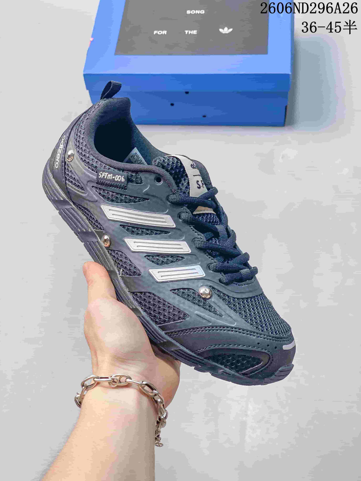 Dark blue-gray Adidas SFTM-006 low-top sneaker with dark laces and contrasting side details.