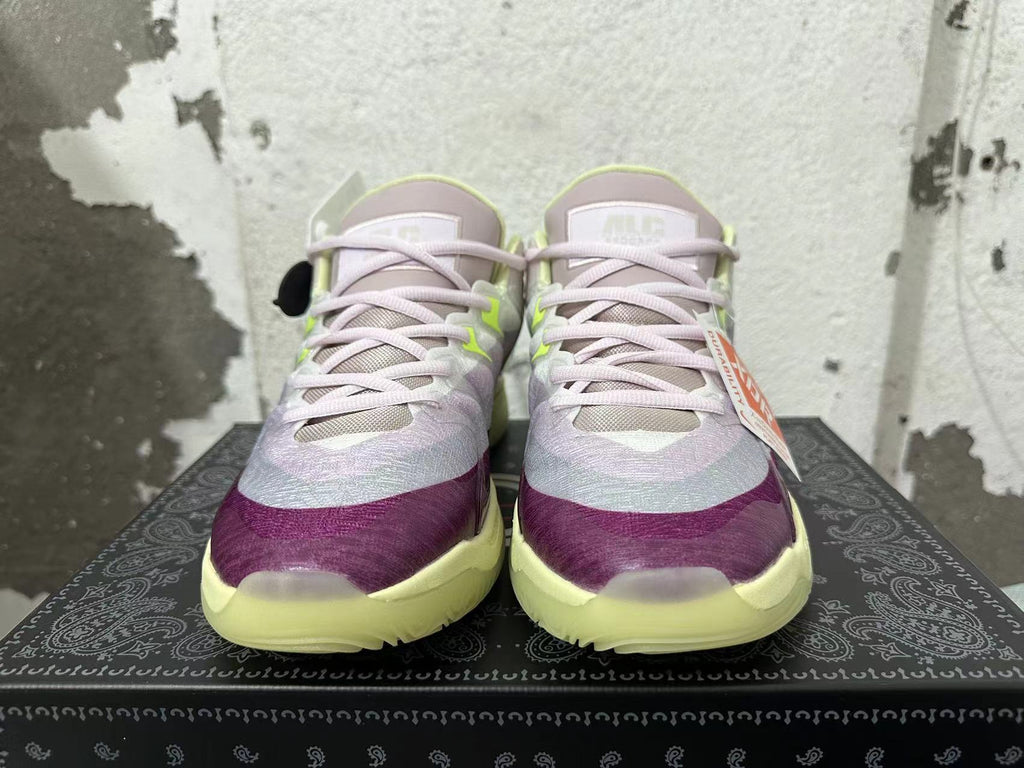 Front view of Nike basketball shoes with light purple laces, purple toe accents, and pale lime details.