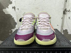 Front view of Nike basketball shoes with light purple laces, purple toe accents, and pale lime details.