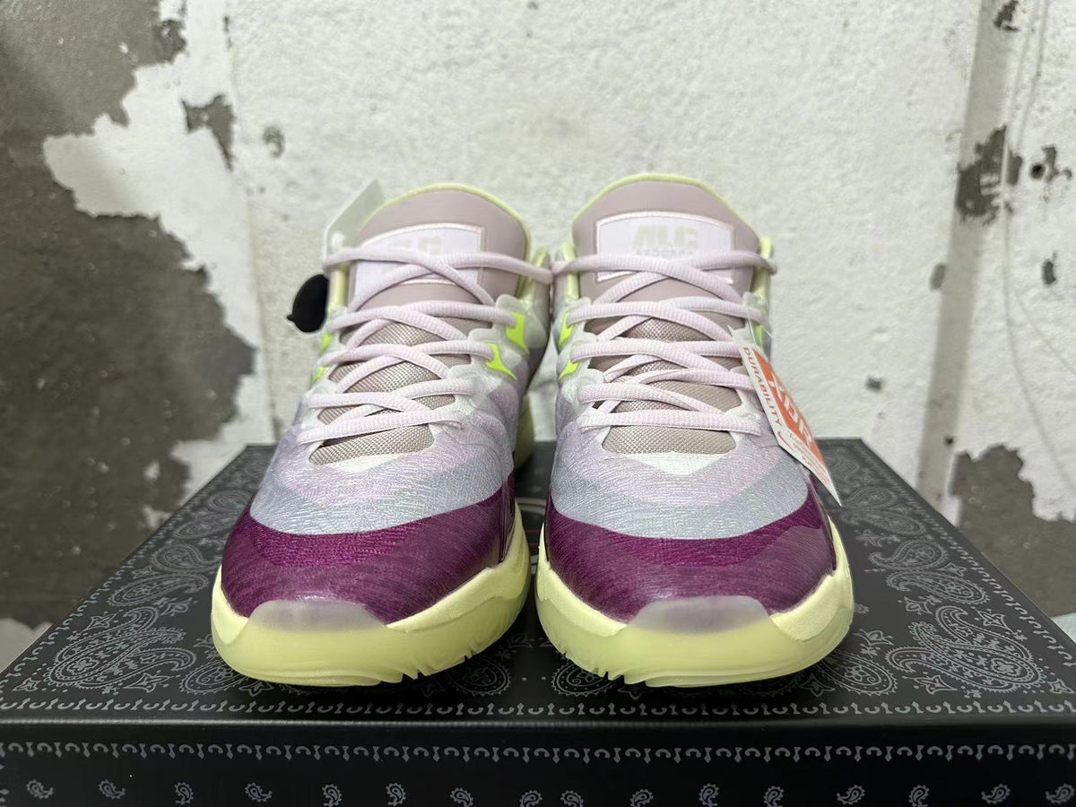 Front view of Nike basketball shoes with light purple laces, purple toe accents, and pale lime details.