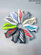 Several adidas Adizero sneakers arranged together in white, black, neon green, red, blue, turquoise, gray, and cream colorways.