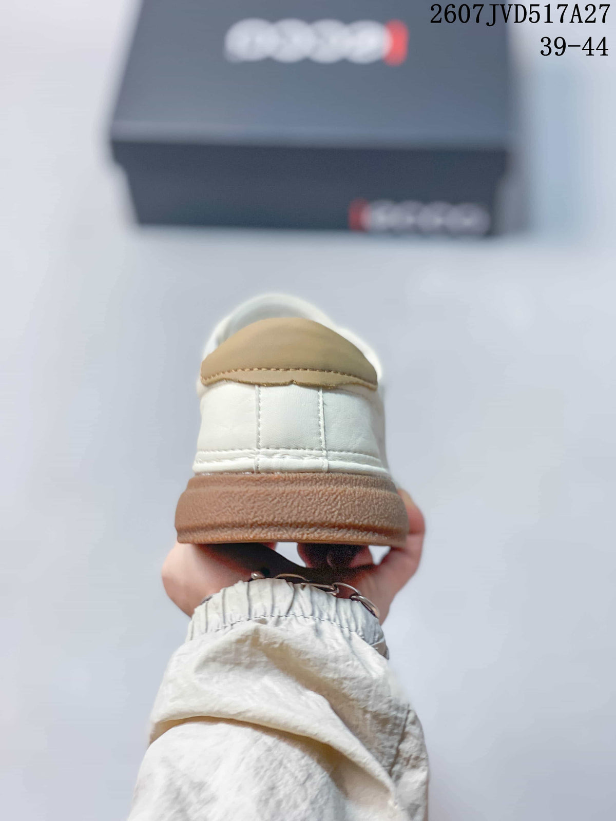 Rear view of the white sneaker showing the tan heel detail and gum-colored sole.