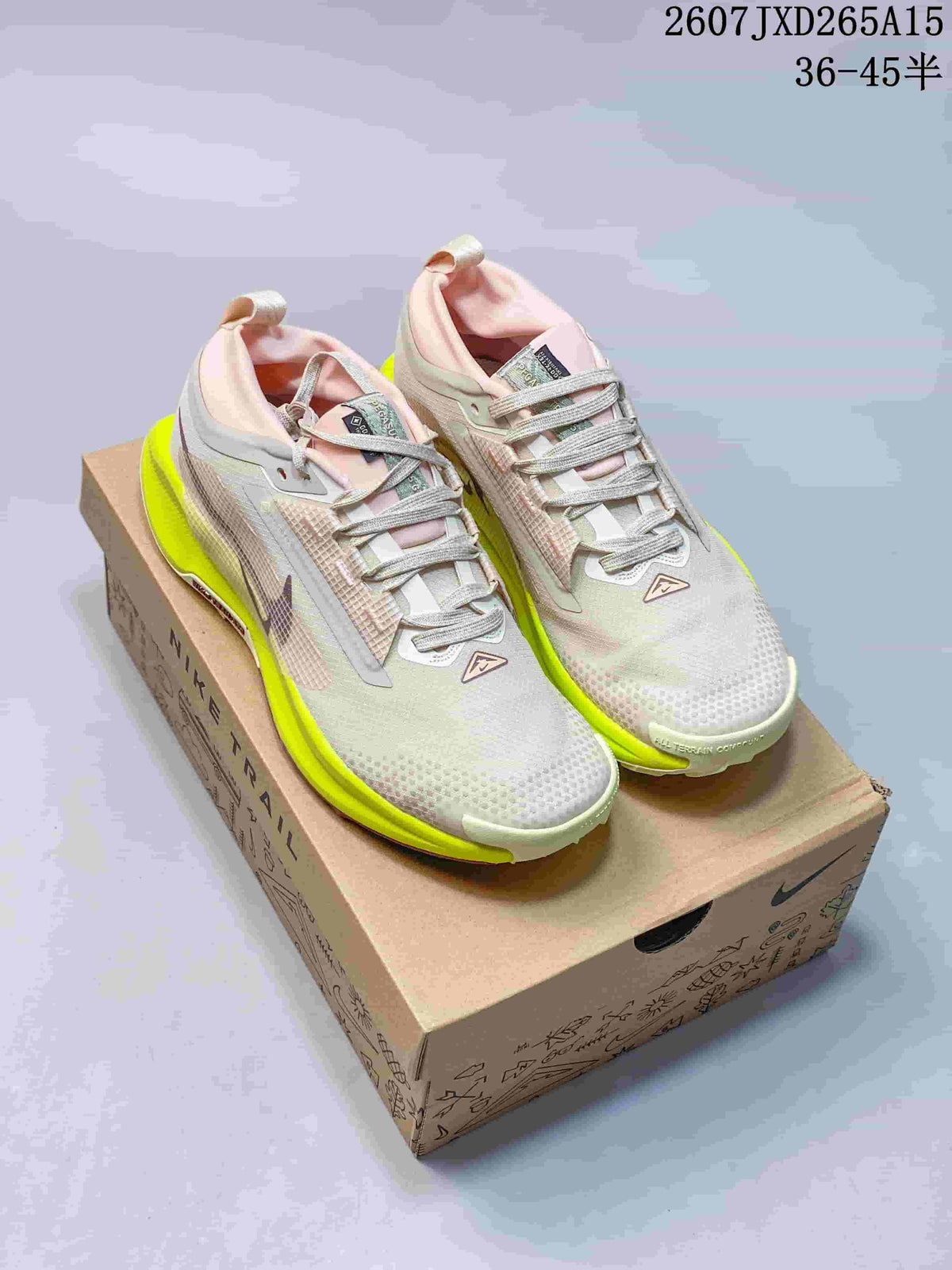 Pair of Nike Pegasus Trail 5 sneakers in light gray, pink, and neon yellow displayed on a Nike shoebox; image text shows style reference 2607JXD265A15 and size range 36–45.5.
