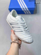 Angled side view of the white sneaker with silver stripes and a gum-colored sole.