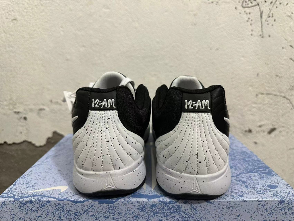 Rear view of black and white basketball shoes showing Kobe heel branding and a speckled midsole