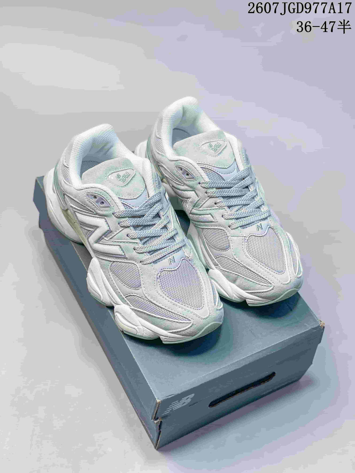 Pair of pale mint and white New Balance 9060 sneakers viewed from above on a shoebox.