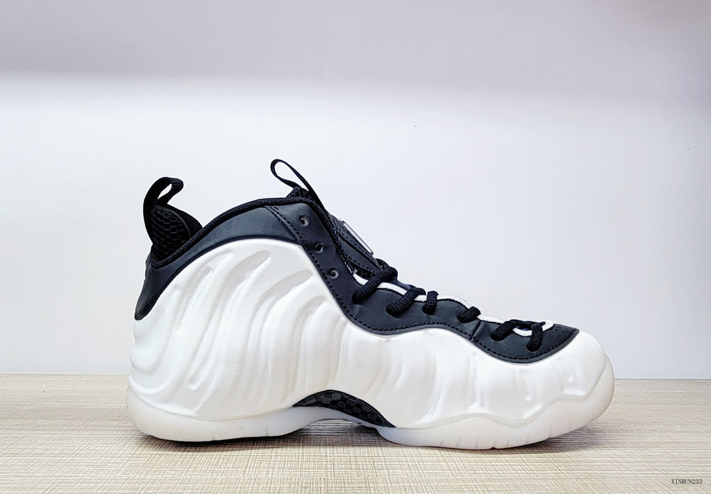 Side view of a white Nike Air Foamposite One high-top with black laces and collar