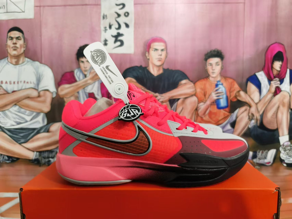 Side view of a red and gray Nike basketball shoe with a black Swoosh
