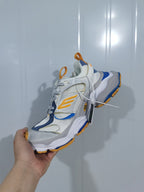Top and side view of the New Balance 9174 sneaker showing the mesh sections, layered panels, orange detailing and blue trim.