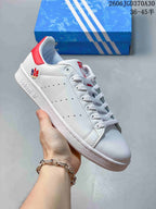White Stan Smith-style sneaker with a multicolor heel emblem and a red heel tab.
