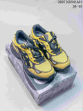 Pair of yellow and charcoal ASICS GEL-NYC 2.0 sneakers on a shoebox