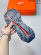 Outsole view of a sneaker showing a patterned black rubber tread and a red central midsole element.