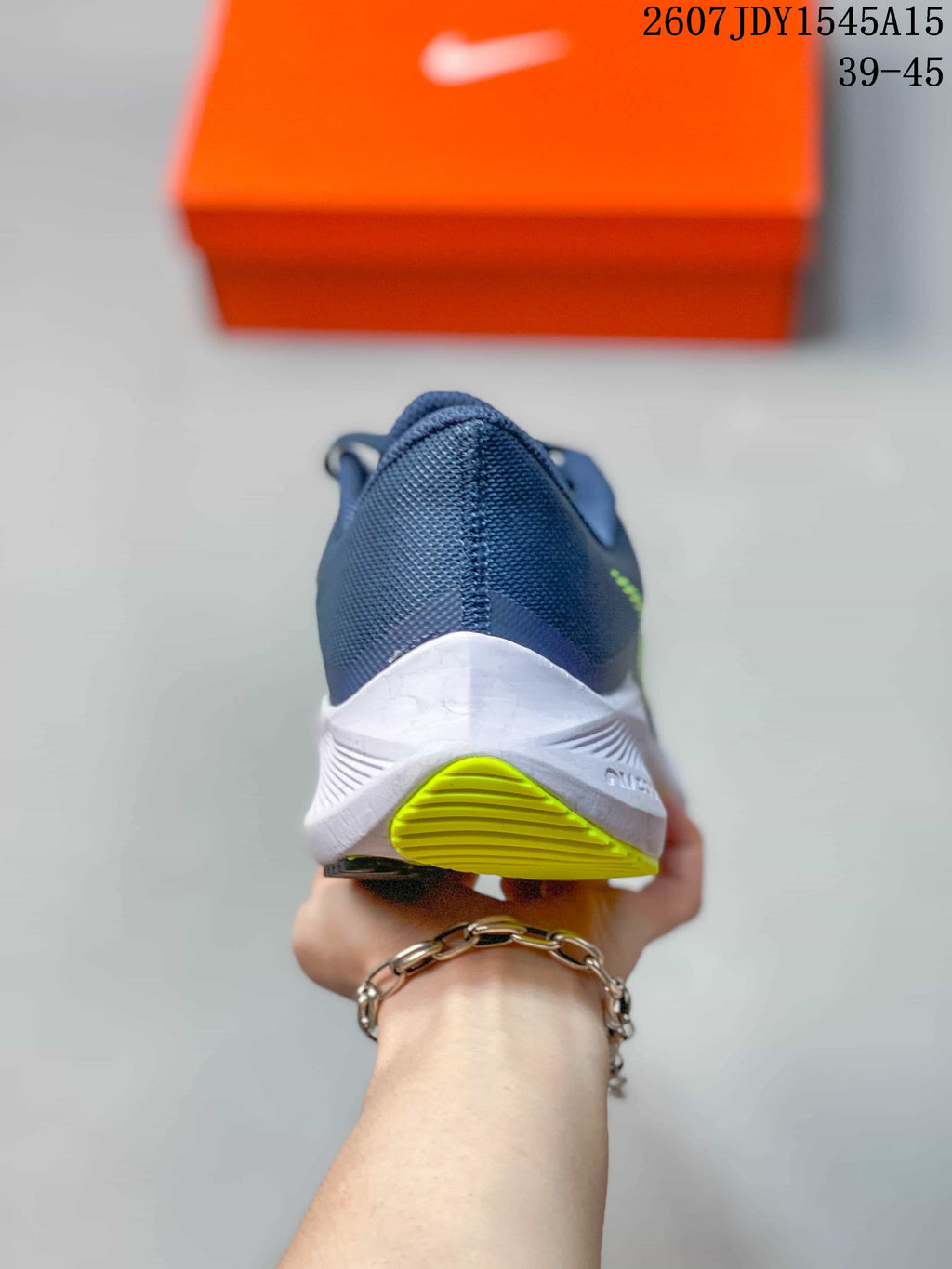 Rear view of a Nike Zoom Winflo 8 shoe showing the navy heel, white midsole, and lime green outsole accent.