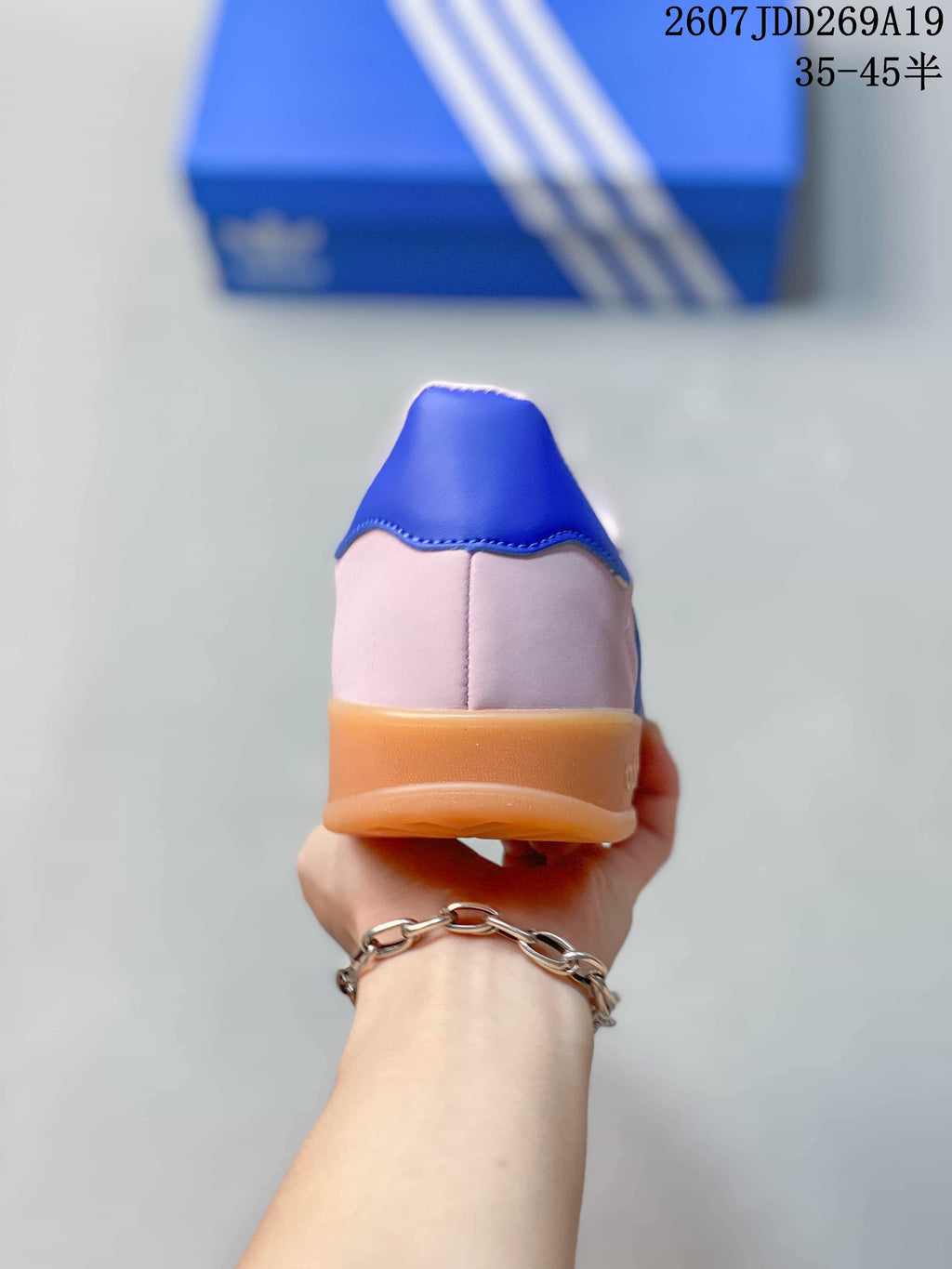 Rear view showing the blue heel tab, pink upper, and gum-colored outsole.
