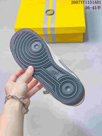 Close-up of the dark gray patterned outsole and yellow shoe box.