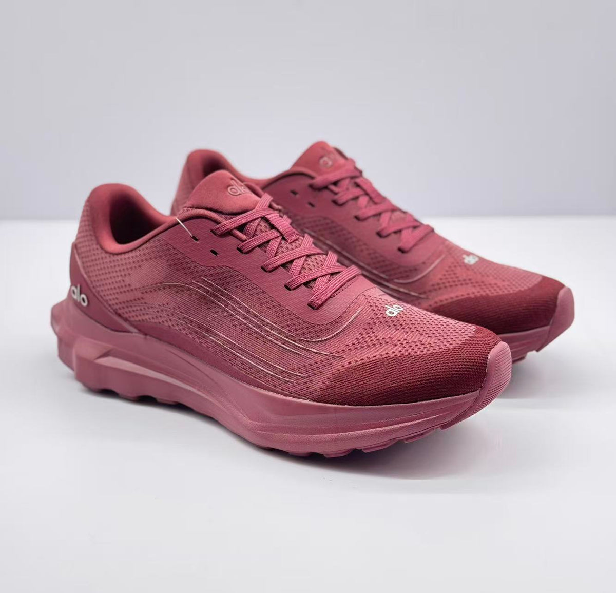 Pair of burgundy alo Runner sneakers shown from a three-quarter front angle.