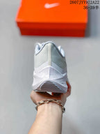 Rear view of a light gray Nike running shoe showing the mesh heel, padded collar, midsole, and outsole tread.