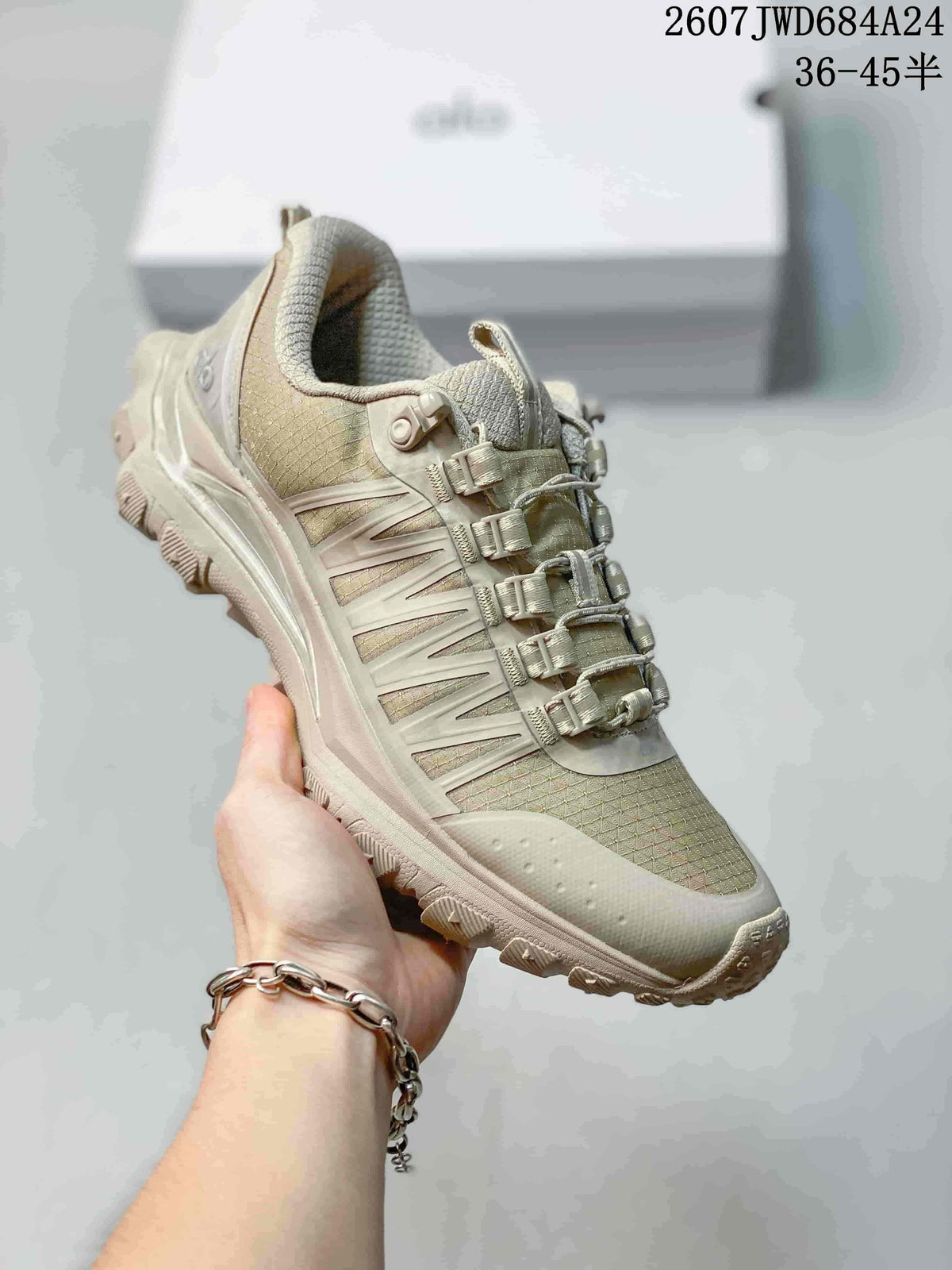 Three-quarter view of the beige-toned Alo sneaker showing the layered side panels, lace system, padded collar, and textured outsole.