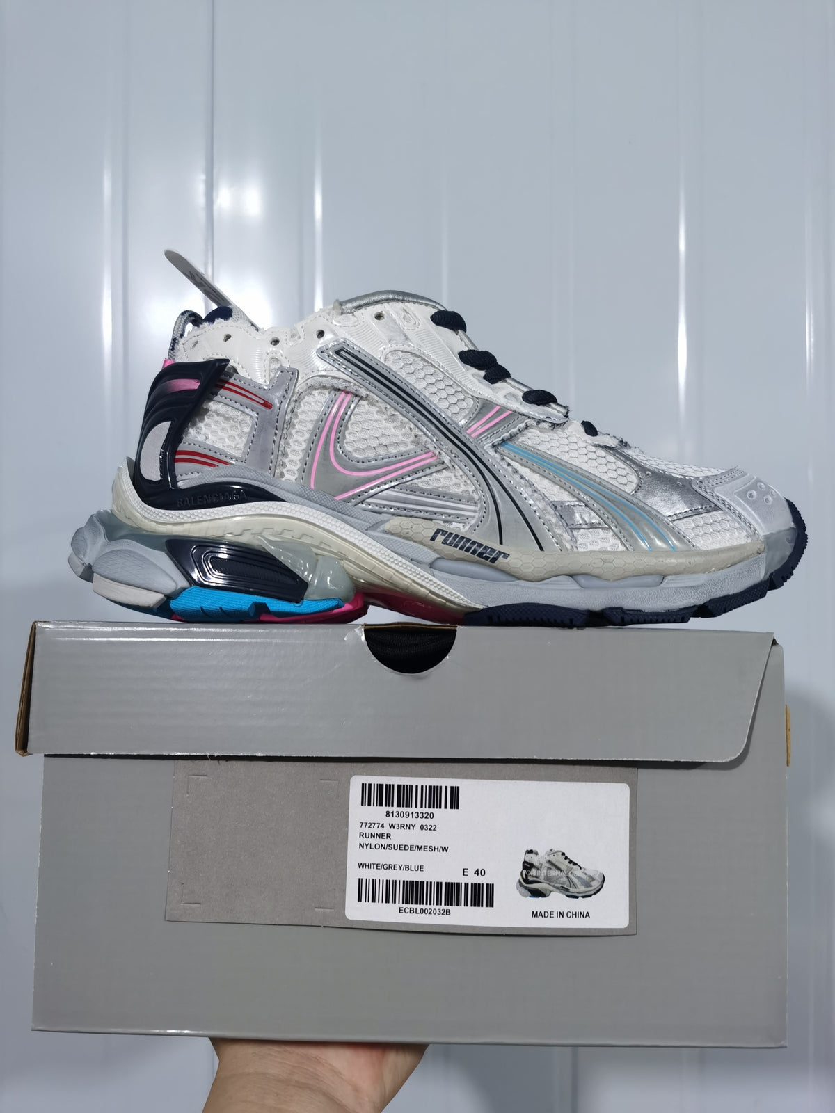 Balenciaga Runner sneaker in white, grey and blue with pink accents, displayed on its shoebox with a visible EU 40 label.