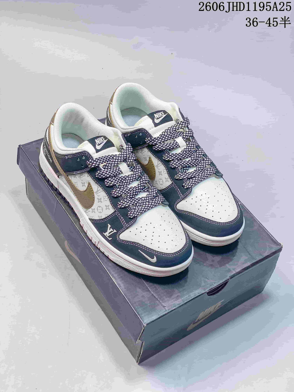 White and navy low-top sneakers with a monogram-print side panel and patterned laces, pictured on a box.
