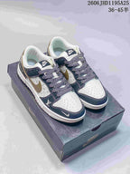 White and navy low-top sneakers with a monogram-print side panel and patterned laces, pictured on a box.