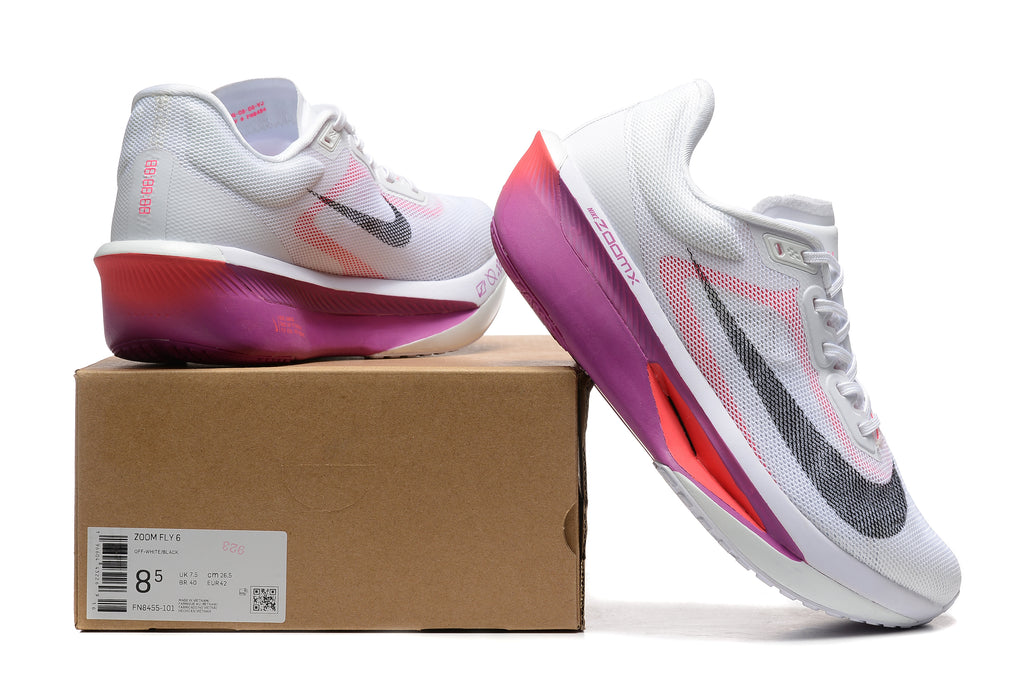 White Nike Zoom Fly 6 shoes with pink and purple accents beside a box showing a sample size label
