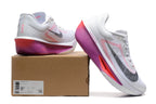 White Nike Zoom Fly 6 shoes with pink and purple accents beside a box showing a sample size label